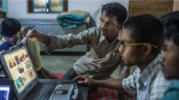  ?? ATUL LOKE/THE NEW YORK TIMES PHOTOS ?? Babulal Singh Neti teaching trainees how to use Google on a laptop at the office of a nongovernm­ental organizati­on where he works in Anuppur, India.