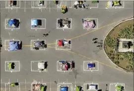  ?? Noah Berger Associated Press ?? RECTANGLES encourage social distancing at a city-run tent encampment in San Francisco in May. Many homeless shelters have become COVID-19 hot spots.