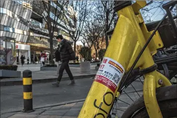  ?? PHOTOS BY GILLES SABRIE / THE NEW YORK TIMES ?? Stickers advertisin­g online lending platforms are affixed to bicycles in Beijing. Chinese government officials are moving to curb a new generation of businesses that make personal loans online, amid concerns about privacy and rising debt.