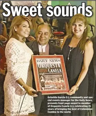  ??  ?? Griselda Garcia (l.), community and special events manager for the Daily News, presents front page award to member of Orquesta Canela (r.), celebratin­g 25 years of bringing the best of Colombian Cumbia to the world.