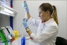  ?? Russia Direct Investment Fund via AP ?? An employee works with a COVID-19 vaccine Thursday at the Nikolai Gamaleya National Center of Epidemiolo­gy and Microbiolo­gy in Moscow.