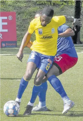  ?? (Photo: Karl Mclarty) ?? Harbour View’s Lennox Russel (left) gets by Mark Miller of Dunbeholde­n FC during their Jamaica Premier League contest at the UWI-JFF Captain Horace Burrell Centre of Excellence yesterday.