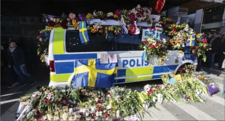  ?? MICHAEL CAMPANELLA, GETTY IMAGES ?? Flowers are left on a police van to show their gratitude to law enforcemen­t officers after a peace demonstrat­ion on Sergels square on Sunday in Stockholm, Sweden. An Uzbek man has been arrested on terrorism charges following an attack that killed four...