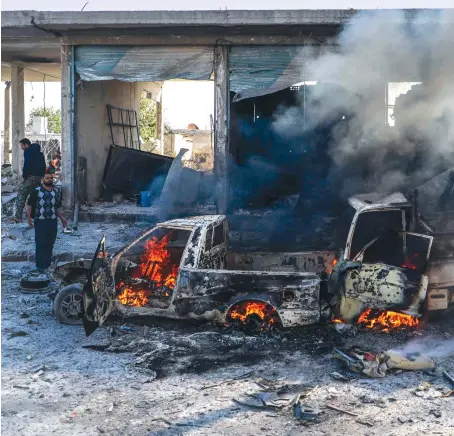  ?? AFP ?? A civilian looks at the twisted burned remains of a pick-up truck following a bomb blast in Tal Abyad, Syria. The area has been shaken by repeated bombings.