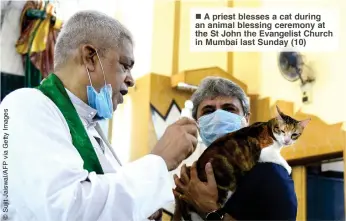  ?? ?? A priest blesses a cat during an animal blessing ceremony at the St John the Evangelist Church in Mumbai last Sunday (10)