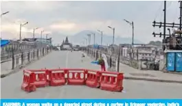  ?? — AFP ?? KASHMIR: A woman walks on a deserted street during a curfew in Srinagar yesterday. India’s home affairs minister has hailed “historic” legislatio­n to bring Kashmir under its direct control, as New Delhi stepped up its clampdown on dissent in the restive Muslim-majority region.