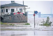  ?? FOTOS: DPA ?? In Köln sind nach dem Hochwasser im Saarland Teile des Uferbereic­hes am Rhein überflutet.