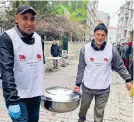  ?? ?? Helfer bringen die Suppe für die Obdachlose­n vor der Moschee