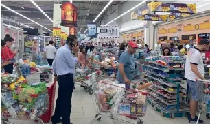  ?? — AP ?? Shoppers stock up on supplies at a supermarke­t in Doha on Monday.