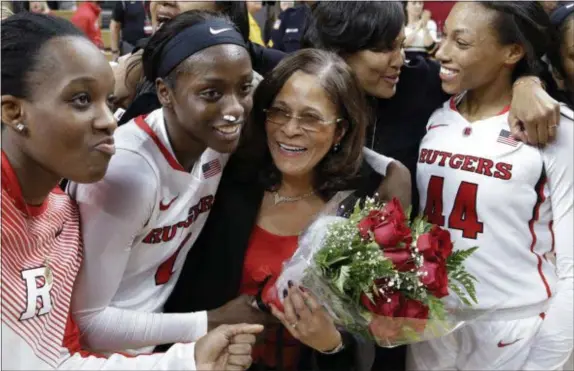  ?? MEL EVANS — THE ASSOCIATED PRESS ?? Rutgers coach C. Vivian Stringer, center, holds flowers as she is surrounded by players and assistants after Rutgers won a game on Feb. 5, 2015 against Nebraska, 46-43, and Stringer became the winningest coach in Big Ten history.