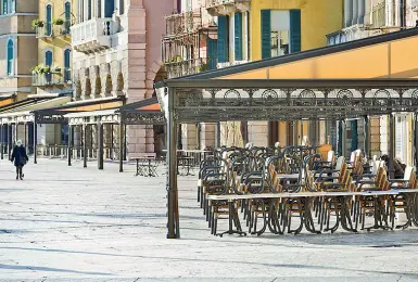  ??  ?? Settore in crisi Tavolini accatastat­i davanti a un locale in piazza Bra