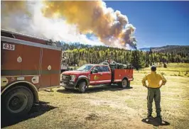  ?? JIM WEBER AP ?? Firefighte­r Ryan Le Baron watches the wildfire burn across a ridgeline near the Taos County line in northern New Mexico.