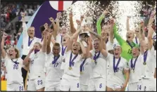  ?? Associated Press ?? England’s Leah Williamson (center left) and Millie Bright lift the trophy after winning the Women’s Euro 2022 final soccer match against Germany, Sunday, at Wembley stadium in London. England won 2-1.