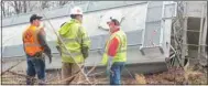  ?? TIMES photograph by Annette Beard ?? Arkansas & Missouri Railroad officials including the engineer, conducter and transporta­tion director look over the derailed train cars in Garfield just off Roberts Loop.