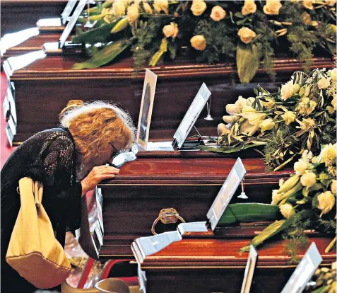  ??  ?? A woman kisses a coffin before a state funeral for some of the victims, and top left, Cardinal Angelo Bagnasco, Archbishop of Genoa, blesses the coffins
