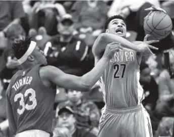  ??  ?? Pacers center Myles Turner fouls Nuggets guard Jamal Murray during the second half of Denver’s 125-117 victory Friday night in Indianapol­is. R Brent Smith, The Associated Press