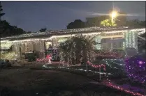  ?? KEVIN D. THOMPSON / THE PALM BEACH POST ?? About 20 neighbors and volunteers from TrustBridg­e Health put up all the lights and decoration­s.