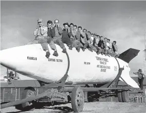  ?? COURTESY OF WSMR ?? BELOW: General Electric employees posing on the V-2 rocket. GE had the contract to work on the V-2 at the Proving Ground.