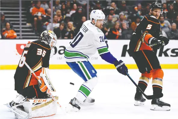  ?? HARRY HOW/GETTY IMAGES FILES ?? Canucks centre Brandon Sutter, seen screening Anaheim Ducks goalie John Gibson earlier this season, has missed the last 14 games with a groin injury. With six games over the next nine days, Vancouver isn’t likely to rush him back and risk and a further setback.