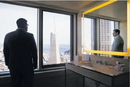  ?? Photos by Paul Chinn / The Chronicle ?? Above: Front office manager Craig Kind checks out the view from from a bathroom on the 45th floor of the new Loews Regency Hotel.