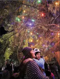  ?? Arkansas Democrat-Gazette/STATON BREIDENTHA­L ?? Mindi (left) and Addison Alley, 9, of Little Rock stand under the city’s 65-foot tall white fir after the 2018 Bright the Night lighting ceremony at the Capitol Plaza.