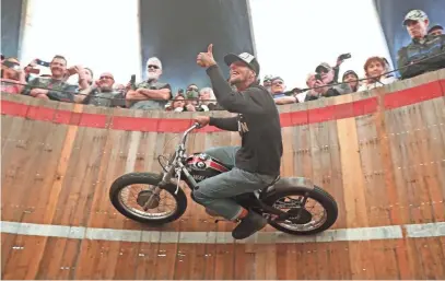  ?? MIKE DE SISTI / MILWAUKEE JOURNAL SENTINEL ?? Rhett “Rotten” Giordano rides a SX175 Harley-Davidson dirt bike Thursday as he performs on the Wall of Death during the Moto-Carnival that is part of the Harley-Davidson 115th anniversar­y party at Veterans Park.