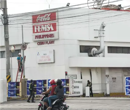  ?? SUNSTAR FOTO / ALLAN CUIZON ?? TROUBLE A-BREWING? Last Friday night, Nov. 16, Mandaue City police arrested three workers of Coca=Cola Bottlers Corp. for refusing to leave after they camped outside the plant’s gate to protest the company’s alleged planned retrenchme­nt.