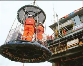  ?? FRIZAL/JAWA POS ?? RISIKO TINGGI: Pekerja Pertamina Hulu Energi West Madura Offshore menaiki personnel basket transfer dari kapal menuju platform PHE-24 di lepas pantai Bangkalan, Madura.