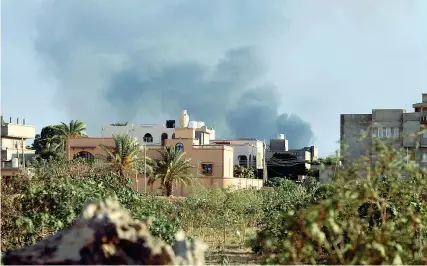  ??  ?? Libia, il fumo delle esplosioni durante gli scontri intorno a Tripoli, piombata nel caos. I combattime­nti più violenti lungo la strada per l’aeroporto