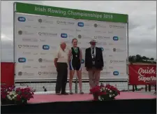  ??  ?? Orla O’Loughlin on the podium receiving her medal at the Irish rowing Championsh­ips with coach John O’Keeffe to her left.