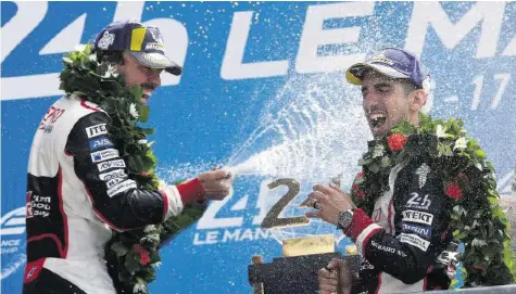  ?? AP ?? Sébastien Buemi (r.) bekommt von Teamkolleg­e Fernando Alonso eine Champagner-Dusche verpasst.