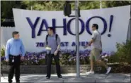  ?? MARCIO JOSE SANCHEZ — ASSOCIATED PRESS ?? People walk in front of a Yahoo sign at the company’s headquarte­rs in Sunnyvale, Calif., in 2014.