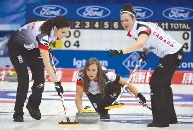  ?? The Associated Press ?? Rachel Homan, centre, of Canada throws a stone against China during the World Women’s Curling Championsh­ip in Beijing, China, on Saturday. Canada won 9-3.