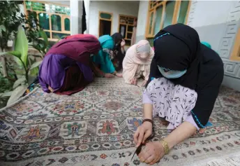  ?? ?? Women weave a carpet at a house in Soton Sang in Dara-i Noor district of Nangarhar province. — AFP photo