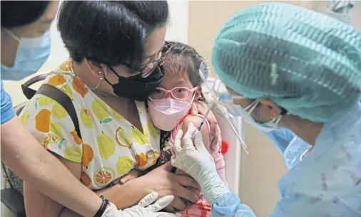  ?? VARUTH HIRUNYATHE­B ?? A girl receives a Pfizer Covid vaccine at Queen Sirikit National Institute of Child Health on Jan 31. She was among the first group of children with underlying medical conditions to receive the vaccine.