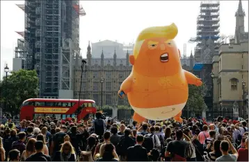  ?? ASSOCIATED PRESS ?? A SIX-METER HIGH CARTOON BABY BLIMP OF U.S. PRESIDENT DONALD TRUMP IS FLOWN as a protest against his visit in Parliament Square backdroppe­d by the scaffolded Houses of Parliament and Big Ben in London, England on Friday.
