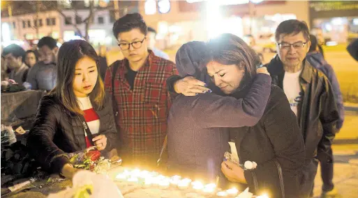  ?? LUCAS OLENIUK/TORONTO STAR ?? A woman embraces well-wisher Cathy Najafi at a makeshift memorial set up on Yonge St. on Monday night after 10 people were killed and 15 injured.