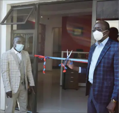  ??  ?? Guest of honour Stanley Dawa (right) about to cut the ribbon at the official opening of the new Mutare Kithen-Link branch with the company’s chief executive Richard Muchaka looking on