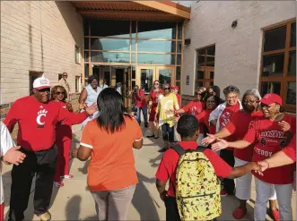  ?? CHUCK HAMLIN / STAFF ?? Dayton Public Schools employees and school board members join community leaders and graduates of the former Roosevelt High School in welcoming students to the first day of classes Monday at Roosevelt Elementary on West Third Street. The school, which was called Dayton Boys Prep in recent years, was renamed Roosevelt because Boys Prep was combined with the World of Wonder school.