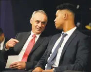  ?? Julio Cortez / Associated Press ?? Major League Baseball Commission­er Rob Manfred, left, talks to Brennan Malone, a right-handed pitcher from IMG Academy in Bradenton, Fla., during the first round of the Major League Baseball draft in Secaucus, N.J., in 2019.