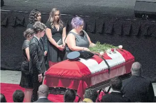  ??  ?? Jackie McLean at the casket of her husband, Const. Robb Costello, joined by her grieving children.