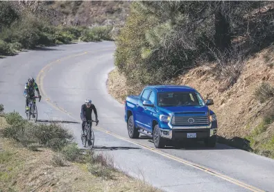  ?? Photos by Stephen Lam / The Chronicle ?? A truck passes cyclists going up Summit Road on Mount Diablo, which can be a dangerous maneuver.