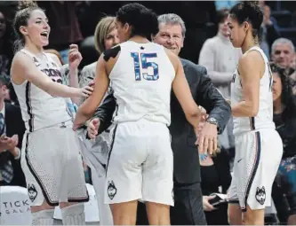  ?? JESSICA HILL THE ASSOCIATED PRESS ?? Connecticu­t head coach Geno Auriemma, centre, and player Katie Lou Samuelson, left, smile as seniors Gabby Williams, centre, and Hamilton’s Kia Nurse leave play for the final time in regular season play during the second half an NCAA college basketball...
