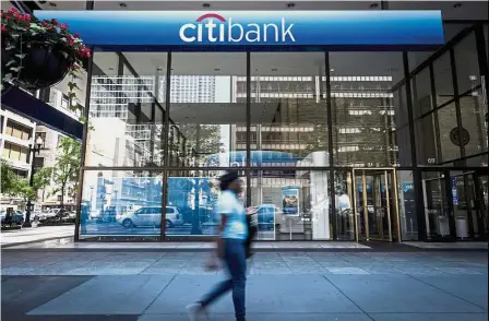  ?? — Bloomberg ?? New vacancies: A woman walking past a Citigroup bank branch in Chicago, Illinois. The choice to expand the bank’s existing broker-dealer in Frankfurt means it will create between 150 and 250 new roles there.
