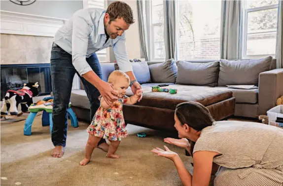  ?? Photos by Brontë Wittpenn/The Chronicle ?? Zach Landman practices walking with then-15-month-old Lucy while Geri Landman offers encouragem­ent at their home in Danville in August.