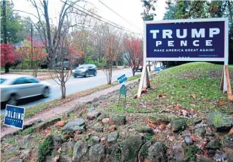  ?? AP ?? STILL STANDING: Cars pass a large Trump-Pence sign in a yard in Wake Forest, N.C., yesterday. Trump was not on the ballot for this midterm election.