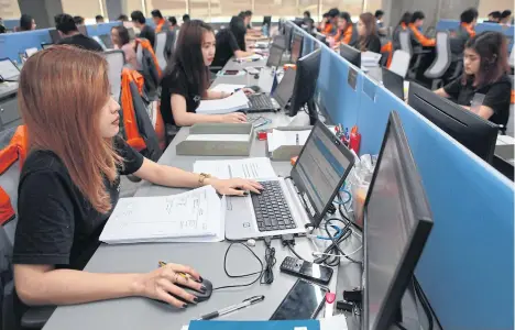  ?? SOMCHAI POOMLARD ?? BELOW The working environmen­t inside Kerry Express, the market leader in Thailand in terms of parcel delivery.