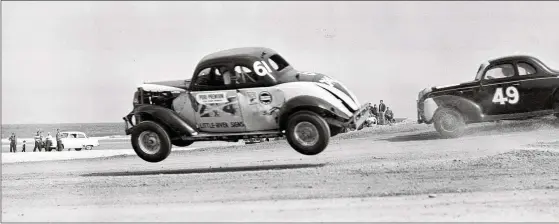  ?? JAMES P. KERLIN / ASSOCIATED PRES FILE ?? In Feb. 14, 1953, Red Farmer (61) of Miami, is airborne after hitting a hole on the four-mile road course during the 100-mile Modified and Sportsmen stock car auto race in Daytona Beach, Fla. Daytona Beach became the unofficial “Birthplace of Speed” in 1903 when two men argued over who had the fastest horseless carriage and decided things in a race on the white, hardpacked sand along the Atlantic Ocean.