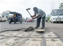  ?? AFP ?? Dadarao Bilhore filling up a pothole on the Western Express highway in Mumbai. —