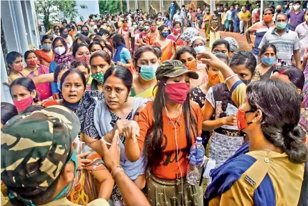  ?? PTI ?? Police officers urge beneficiar­ies to maintain social distancing as they wait in a queue to receive centre at Balurghat in South Dinajpur district of West Bengal on Friday. the Covid-19 vaccine dose at a vaccinatio­n
—